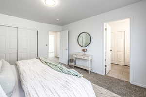 Bedroom with light carpet and a closet