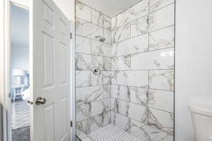 Bathroom featuring toilet and tiled shower