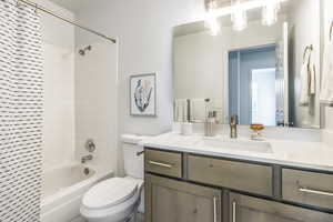 Full bathroom with toilet, vanity, and tiled shower / bath