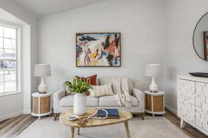 Living room with wood-type flooring and vaulted ceiling