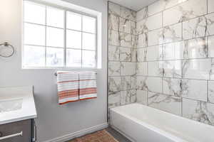 Bathroom with vanity, tile patterned floors, and tiled shower / bath