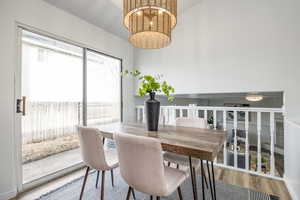 Dining space with hardwood / wood-style floors and a chandelier