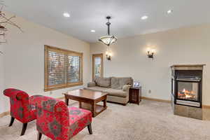 Living room with light carpet and a tile fireplace