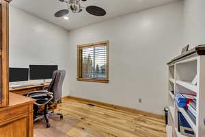 Office space featuring ceiling fan and light hardwood / wood-style floors