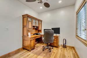 Office space with light hardwood / wood-style flooring and ceiling fan