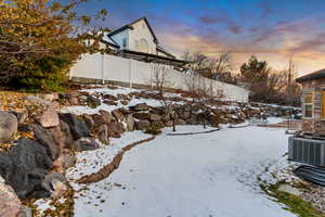 Snowy yard featuring central AC