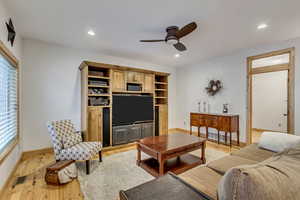 Living room with light hardwood / wood-style flooring and ceiling fan