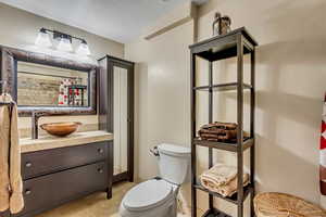 Bathroom featuring tile patterned flooring, a shower with curtain, vanity, and toilet