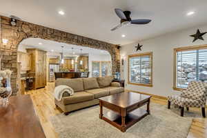 Living room with light wood-type flooring and ceiling fan