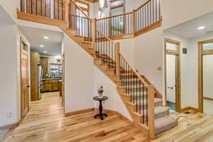 Stairway with plenty of natural light and wood-type flooring