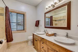 Full bathroom with tile patterned flooring, vanity, shower / bath combination with curtain, and toilet