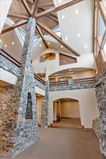 Unfurnished living room with carpet, plenty of natural light, and high vaulted ceiling