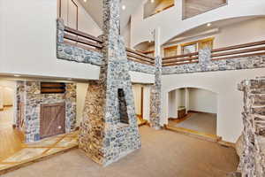 Staircase featuring carpet floors and high vaulted ceiling