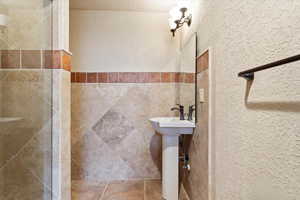 Bathroom featuring a shower and a textured ceiling