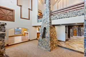 Living room featuring carpet and high vaulted ceiling