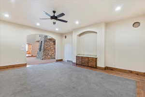 Unfurnished living room with ceiling fan and carpet floors