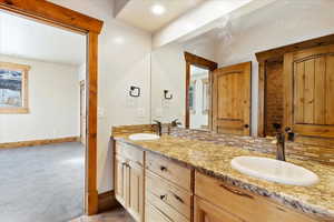 Bathroom with vanity and tasteful backsplash