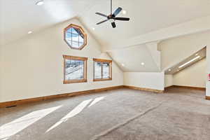 Additional living space featuring carpet flooring, ceiling fan, and high vaulted ceiling