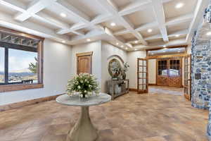 Interior space with beamed ceiling, coffered ceiling, and french doors