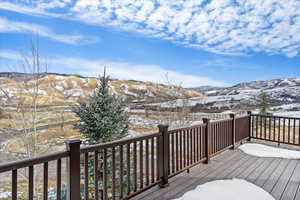 Snow covered deck with a mountain view