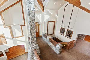 Interior space featuring hardwood / wood-style floors, a high ceiling, and beam ceiling