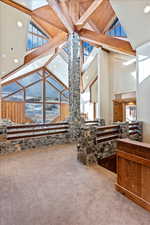 Interior space with beamed ceiling and high vaulted ceiling