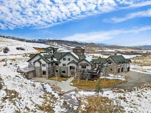 Snow covered house with a mountain view and a garage