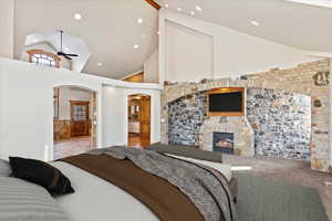 Bedroom featuring carpet, a fireplace, and high vaulted ceiling