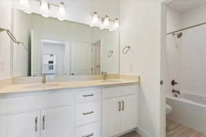 Full bathroom featuring wood-type flooring, vanity, toilet, and tiled shower / bath