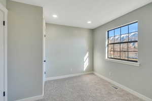 Unfurnished room featuring light colored carpet