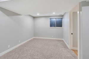 Empty room featuring light colored carpet