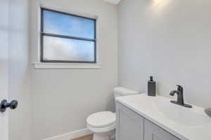 Bathroom with hardwood / wood-style floors, vanity, and toilet