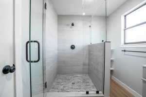 Bathroom featuring a shower with door and hardwood / wood-style flooring