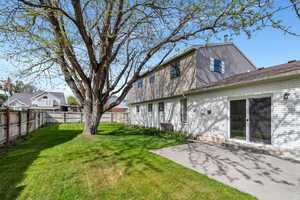 Back of house featuring a patio area, a lawn, and a fenced backyard
