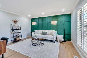 Living room featuring light hardwood / wood-style flooring and ornamental molding