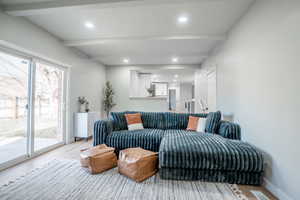 Living room featuring beamed ceiling and light hardwood / wood-style floors