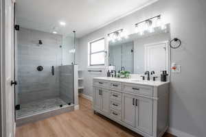 Bathroom featuring hardwood / wood-style floors, vanity, an enclosed shower, and a textured ceiling