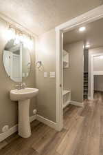 Bathroom featuring hardwood / wood-style floors, a textured ceiling, and sink