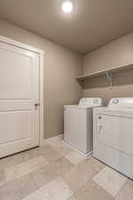 Laundry room with washer and clothes dryer and a textured ceiling