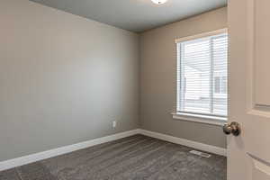 Carpeted spare room featuring plenty of natural light and a textured ceiling