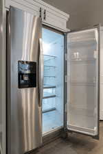 Interior details featuring stainless steel fridge and dark wood-type flooring