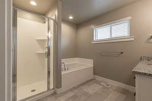 Bathroom featuring vanity and independent shower and bath