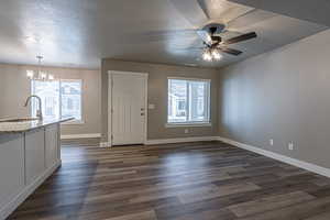 Interior space featuring pendant lighting, plenty of natural light, sink, and dark wood-type flooring