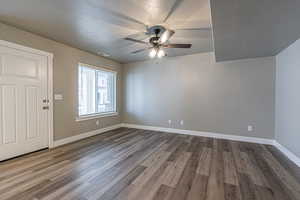 Foyer with wood-type flooring, a textured ceiling, and ceiling fan