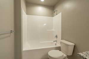 Bathroom featuring toilet and shower / bathtub combination