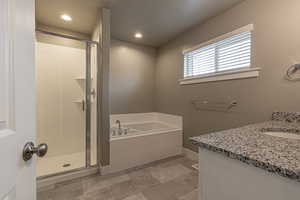 Bathroom featuring vanity and plus walk in shower