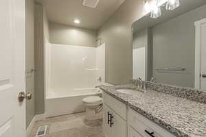 Full bathroom featuring bathing tub / shower combination, vanity, and toilet