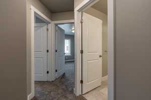 Corridor with carpet floors and a textured ceiling