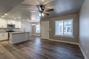 Kitchen with a wealth of natural light, white cabinetry, and appliances with stainless steel finishes