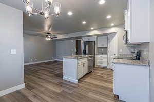 Kitchen with a kitchen island with sink, sink, pendant lighting, dark hardwood / wood-style floors, and white cabinetry